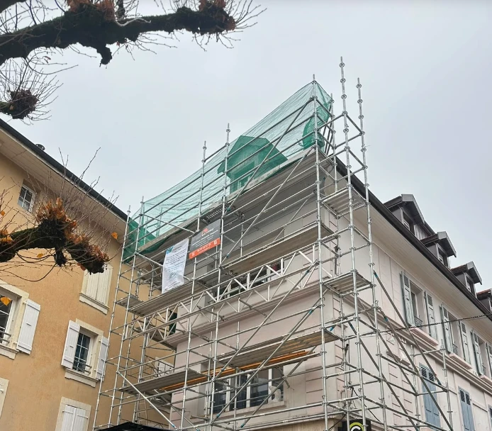 Immeuble du centre de Thonon-les-Bains sous échafaudage, avec filet de protection, pendant la réfection de sa toiture