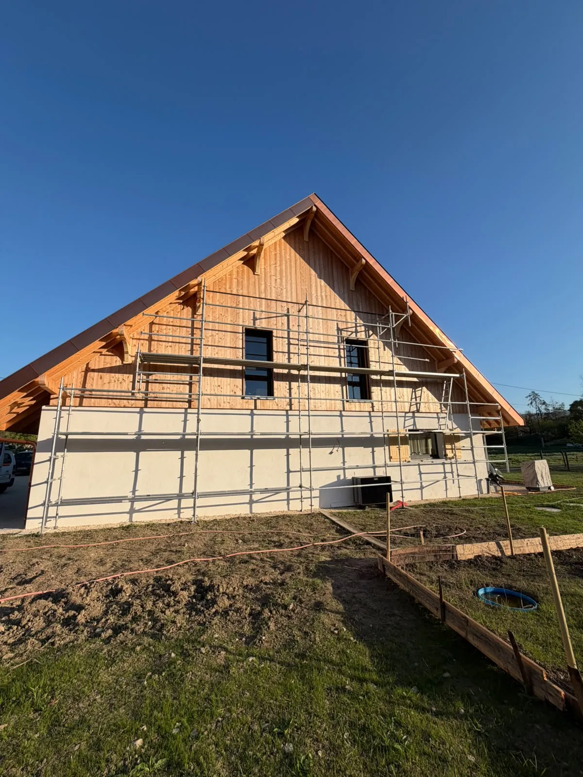 Échafaudage monté le long du pignon d’une maison neuve à bardage bois