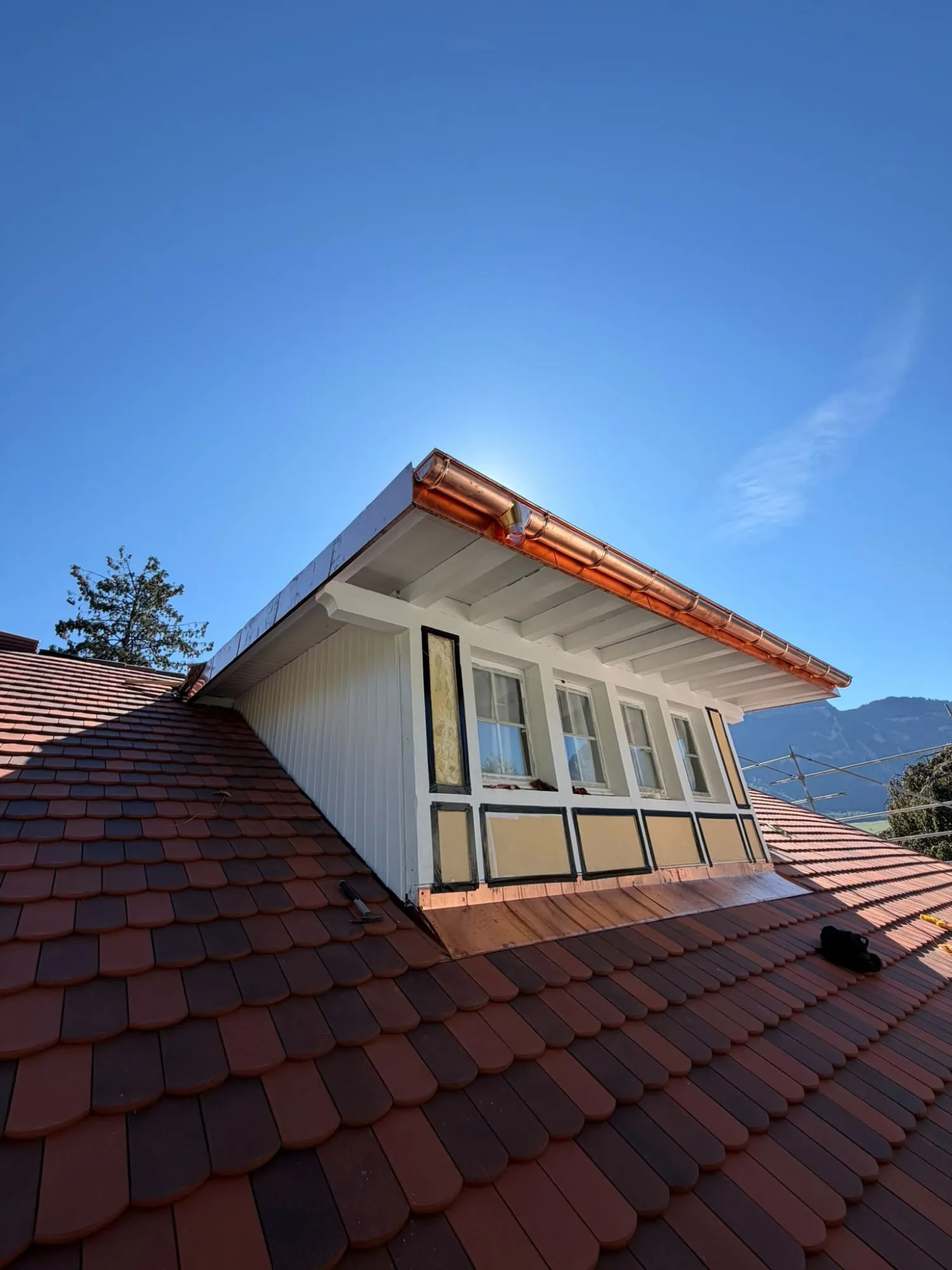 Lucarne rénovée avec gouttière en cuivre et abergement sur une toiture en tuiles plates